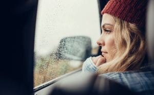 woman looks out a car window thinking about women and addiction and navigating treatment