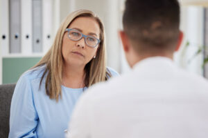 woman with glasses looks a person discussing coping skills for addiction