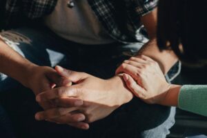 a person holds the forearm of another person while discussing acceptance and commitment therapy techniques