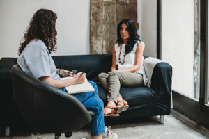 a woman sits on a couch talking to her therapist about subutex treatment 