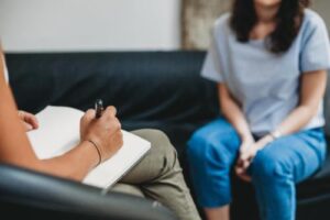 a woman sits on a couch and talks to a therapist in her emdr therapy in mississippi