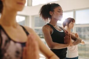 three women practice yoga as part of holistic therapy