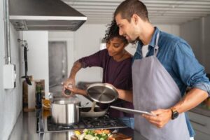 two people are cooking a meal as part of an activity in their life skills training 