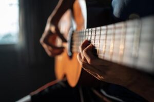 a person plays a guitar as part of one of their music therapy programs 