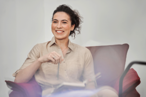 a woman smiles while sitting and talking about the benefits of her suboxone treatment program