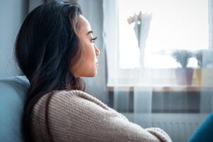 a woman sits and looks in the distance thinking about the signs of a high functioning alcoholic