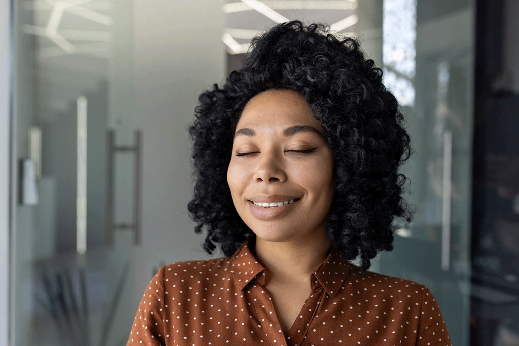 young woman looking calm and smiling slightly as she reflects on the benefits of a holistic detox center