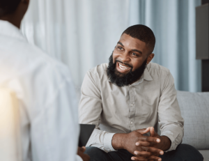 therapist explaining CBT vs DBT and what's the difference to a smiling young man