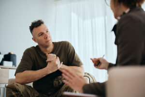 a man sits and talks to a professional in therapy for veterans